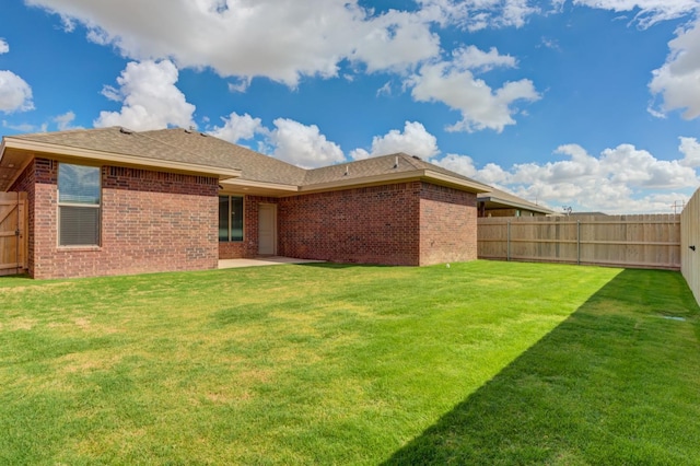 rear view of property featuring a lawn