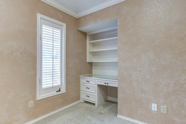 unfurnished office featuring light colored carpet, built in desk, and ornamental molding