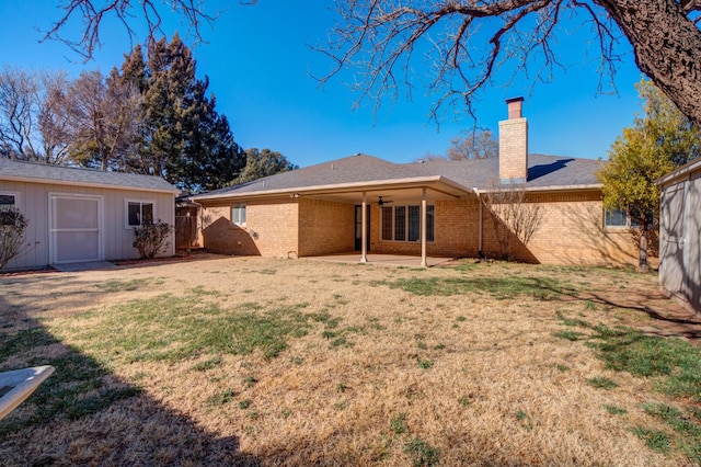 rear view of property with an outbuilding, a yard, and a patio area