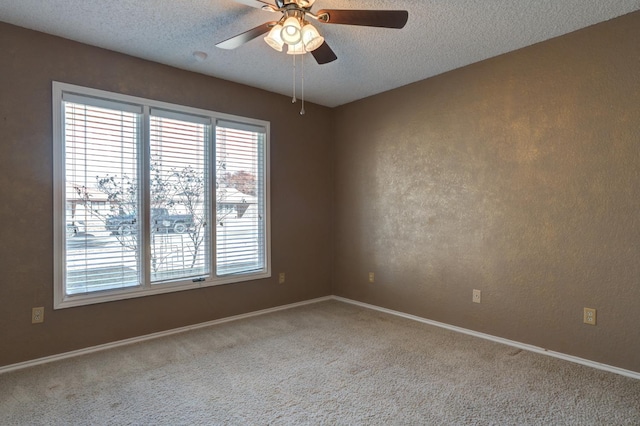 carpeted spare room featuring ceiling fan and a textured ceiling