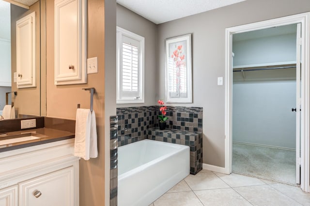 bathroom featuring a bathing tub, tile patterned floors, and vanity