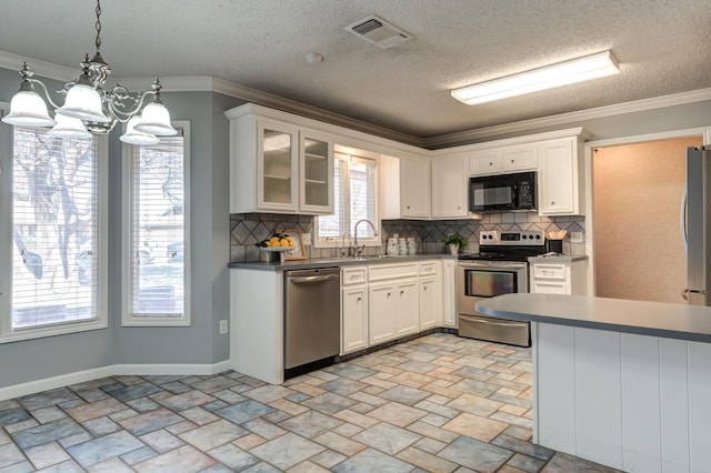 kitchen featuring hanging light fixtures, ornamental molding, stainless steel appliances, and white cabinets