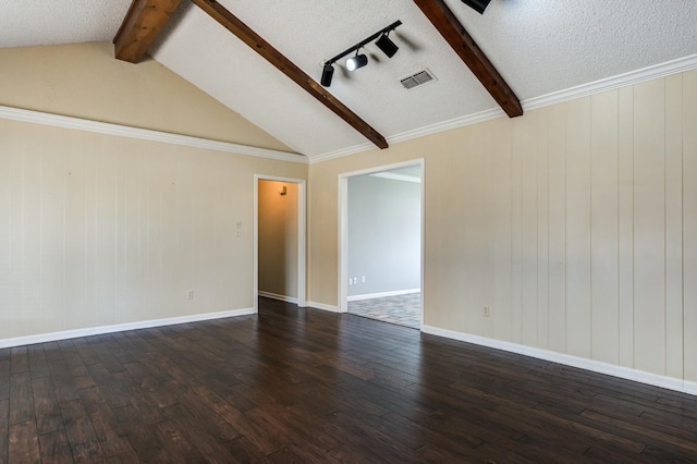 spare room featuring vaulted ceiling with beams, dark hardwood / wood-style floors, and a textured ceiling