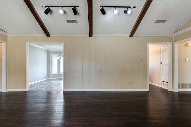 empty room featuring dark wood-type flooring, ornamental molding, lofted ceiling with beams, and a textured ceiling