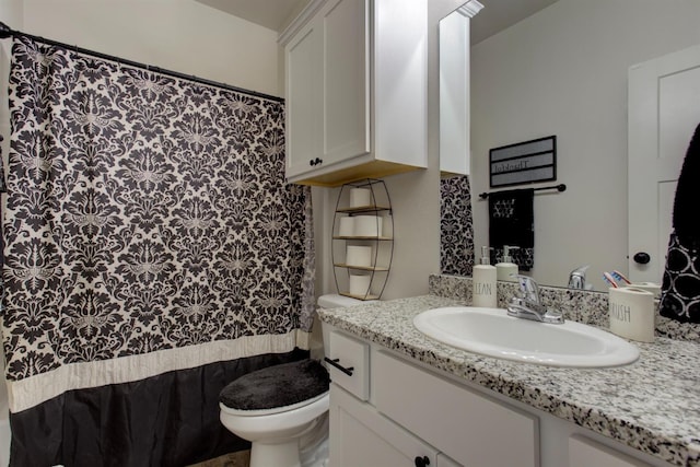 full bath featuring a shower with shower curtain, vanity, and toilet