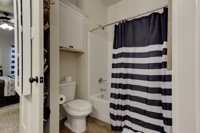 bathroom with toilet, shower / bath combination with curtain, and wood finished floors