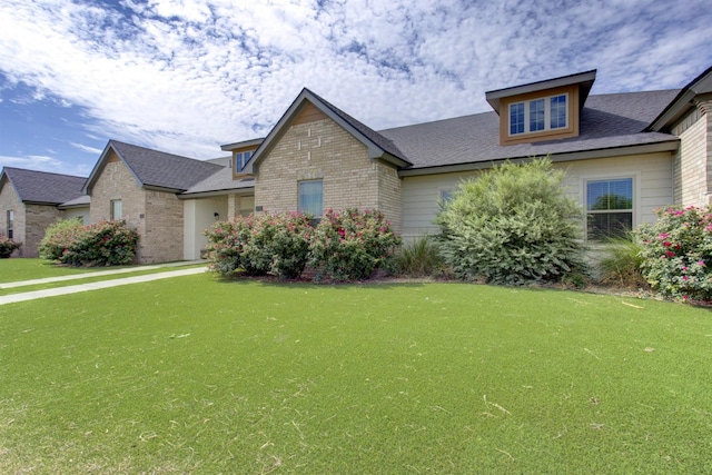 view of front of house featuring a front yard and brick siding