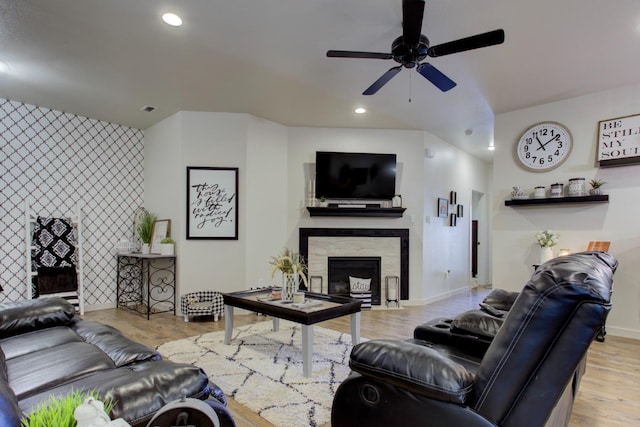 living room with visible vents, baseboards, wood finished floors, a fireplace, and recessed lighting