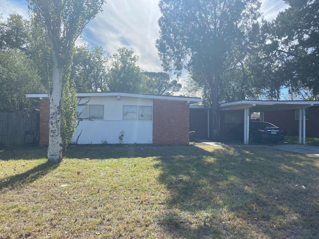 exterior space with a carport and a lawn