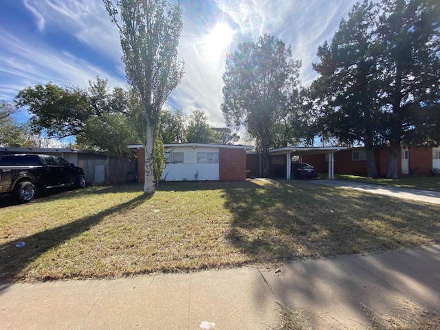 ranch-style home featuring a carport and a front yard