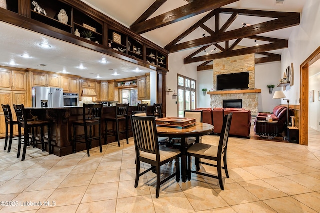 4510 21st St, Lubbock, TX 79407 - dining room with light tile patterned floors, beam ceiling, high vaulted ceiling, and a fireplace