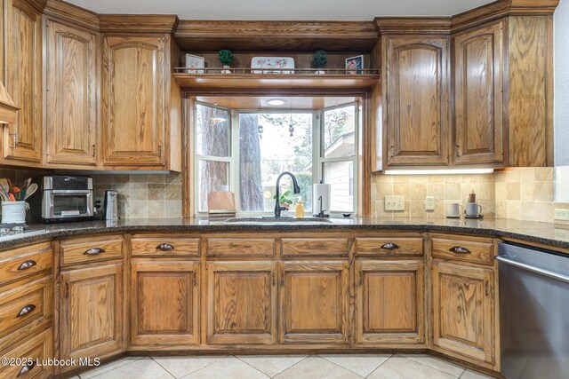 4510 21st St, Lubbock, TX 79407 - kitchen featuring dishwasher, brown cabinetry, dark stone countertops, and decorative backsplash