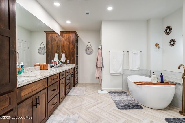 4510 21st St, Lubbock, TX 79407 - bathroom with a freestanding tub, double vanity, and recessed lighting