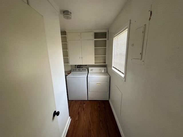 washroom featuring cabinets, dark hardwood / wood-style floors, electric panel, and washer and clothes dryer