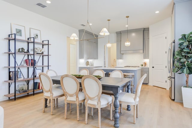 dining room with sink and light wood-type flooring