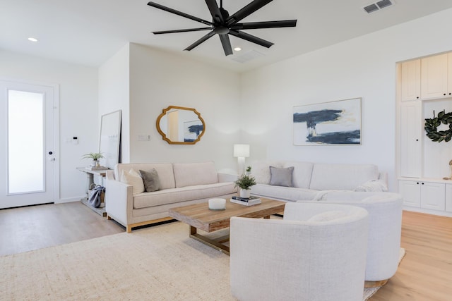 living room with ceiling fan and light wood-type flooring