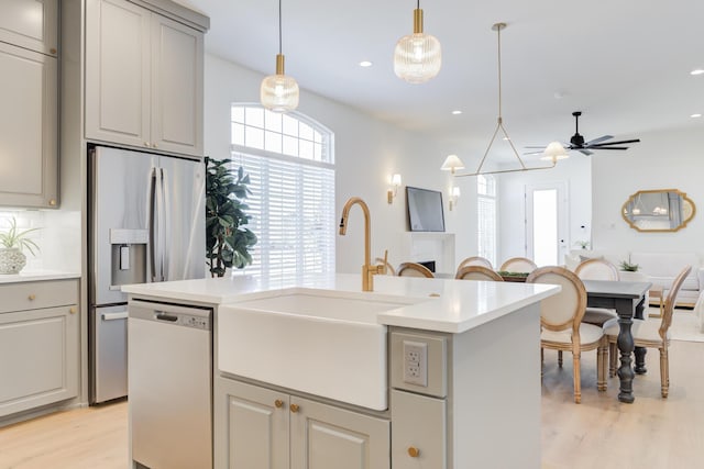 kitchen featuring gray cabinets, sink, hanging light fixtures, a center island, and stainless steel appliances