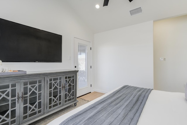 unfurnished bedroom featuring access to exterior, hardwood / wood-style flooring, and vaulted ceiling