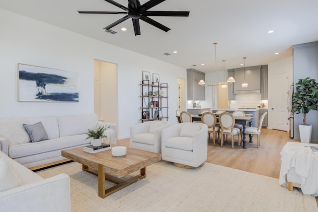 living room featuring light hardwood / wood-style flooring and ceiling fan