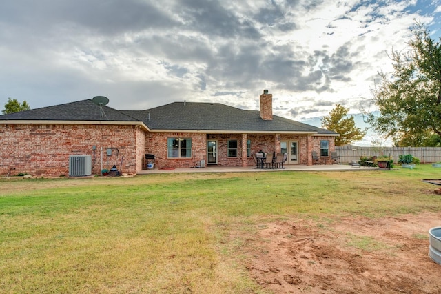 back of property with a patio area, central air condition unit, and a lawn