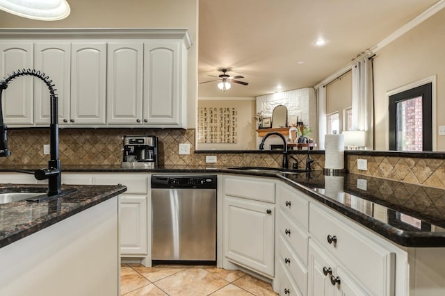 kitchen featuring sink, crown molding, dishwasher, dark stone countertops, and white cabinets