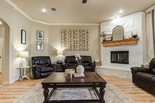 living room with ornamental molding, wood-type flooring, and a fireplace