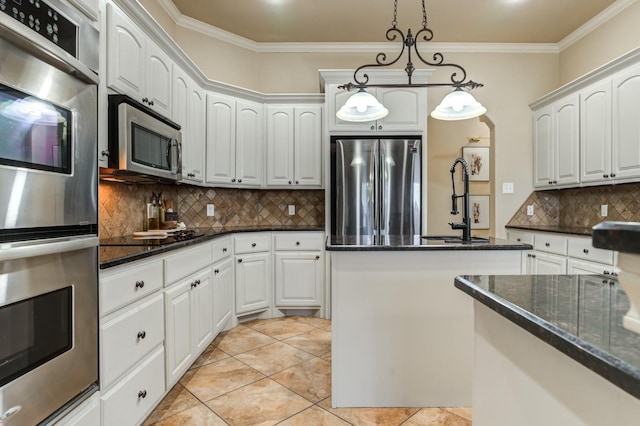 kitchen featuring white cabinetry, hanging light fixtures, dark stone counters, and appliances with stainless steel finishes