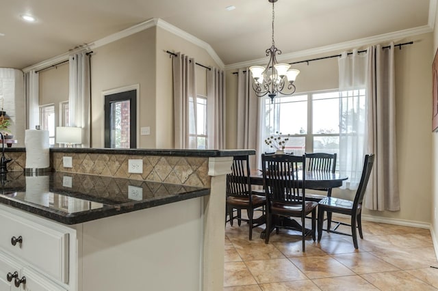 kitchen featuring white cabinetry, ornamental molding, decorative backsplash, decorative light fixtures, and a chandelier