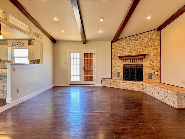 unfurnished living room featuring dark wood-type flooring, a wealth of natural light, a fireplace, and french doors