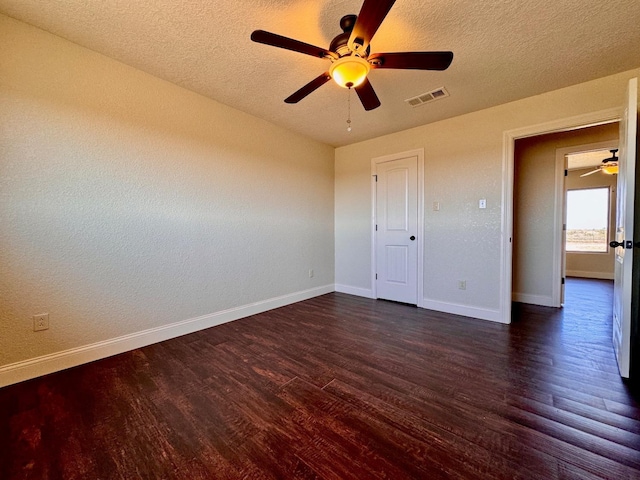 unfurnished bedroom featuring ceiling fan, dark hardwood / wood-style floors, and a textured ceiling