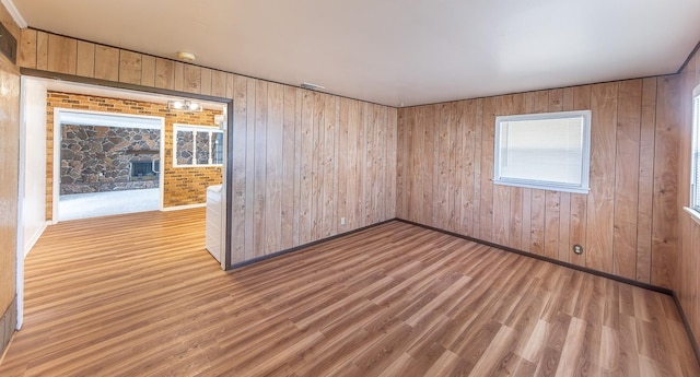 unfurnished room featuring wood-type flooring and wood walls