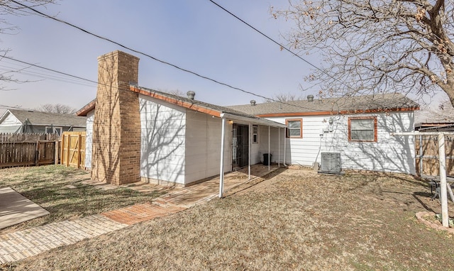 back of house featuring a yard and central AC