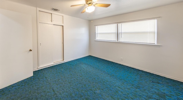 unfurnished bedroom featuring dark colored carpet and ceiling fan