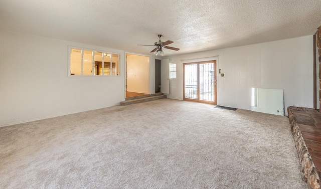 unfurnished living room with ceiling fan, carpet floors, and a textured ceiling