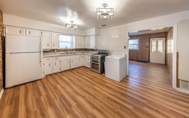 kitchen featuring sink, white cabinetry, white fridge, light hardwood / wood-style floors, and range with two ovens