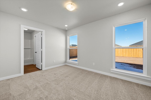 unfurnished bedroom featuring ensuite bathroom and carpet floors