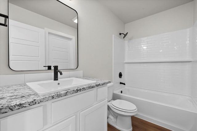 full bathroom featuring vanity, hardwood / wood-style flooring, bathing tub / shower combination, and toilet