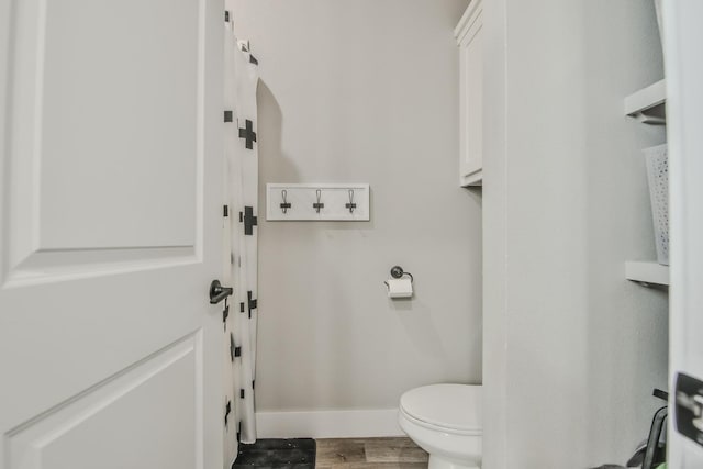 bathroom featuring wood-type flooring and toilet