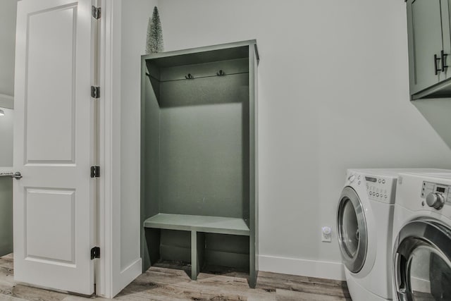 laundry area with cabinets, separate washer and dryer, and light hardwood / wood-style flooring