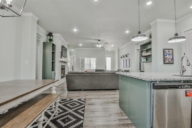 kitchen with a kitchen island, pendant lighting, stainless steel dishwasher, light hardwood / wood-style floors, and crown molding