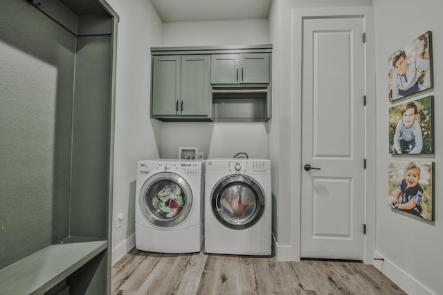 laundry room with separate washer and dryer, light hardwood / wood-style flooring, and cabinets