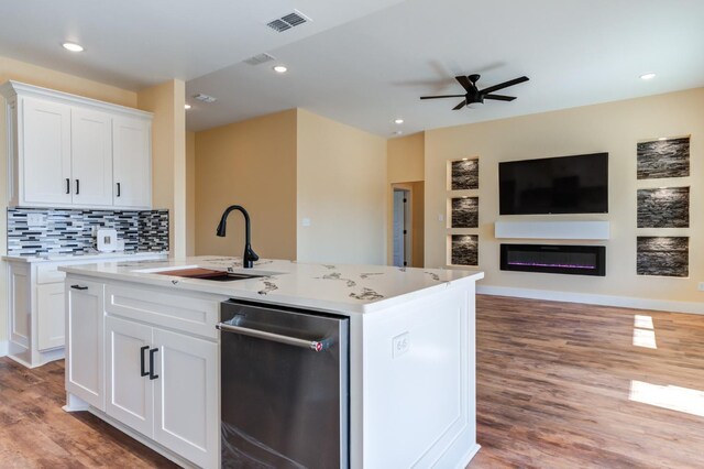 kitchen with white cabinetry, wood-type flooring, sink, and a kitchen island with sink