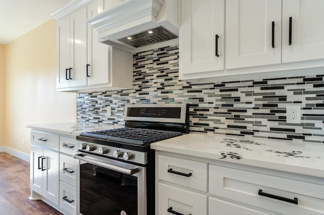 kitchen with premium range hood, white cabinets, backsplash, gas stove, and light stone countertops