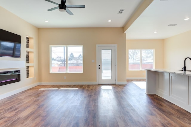 interior space with dark hardwood / wood-style floors, sink, built in features, and ceiling fan