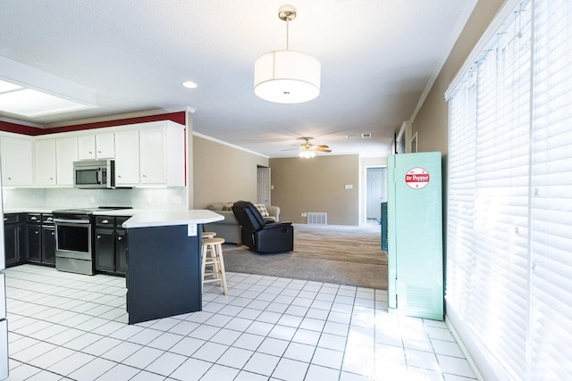 9613 Vicksburg Ave, Lubbock, TX 79424 - kitchen with stainless steel appliances, open floor plan, light colored carpet, a breakfast bar area, and ornamental molding