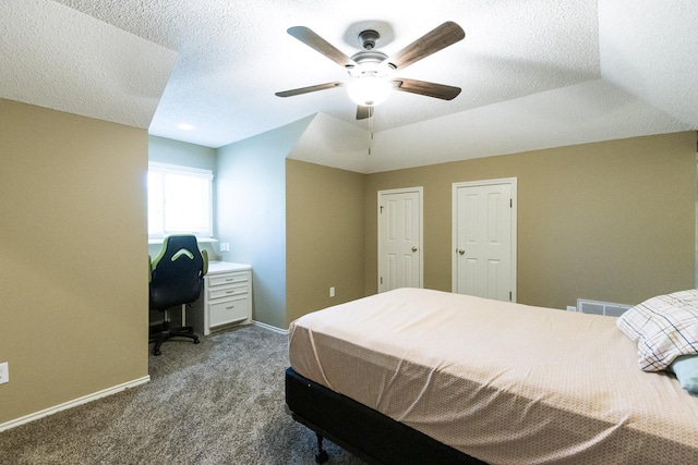 9613 Vicksburg Ave, Lubbock, TX 79424 - bedroom with dark carpet, a textured ceiling, a ceiling fan, and a desk