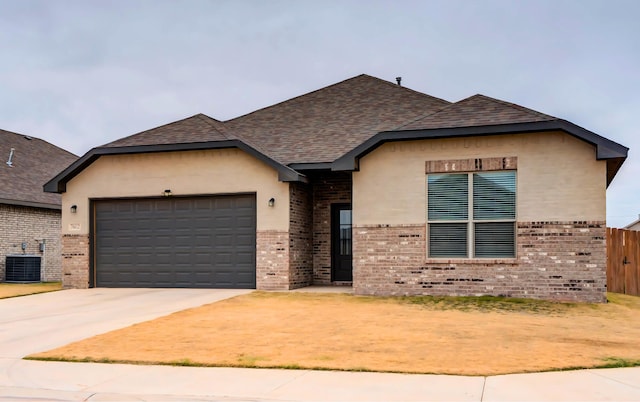 view of front of home featuring central AC unit and a garage