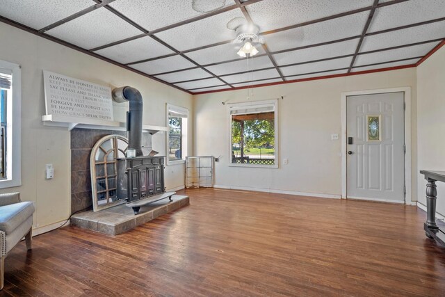 living room with hardwood / wood-style flooring, ceiling fan, and a wood stove