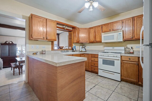 kitchen featuring sink, white appliances, light tile patterned floors, ceiling fan, and kitchen peninsula