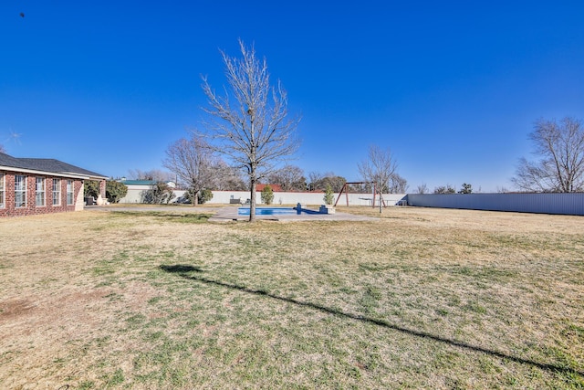 view of yard featuring fence and a fenced in pool